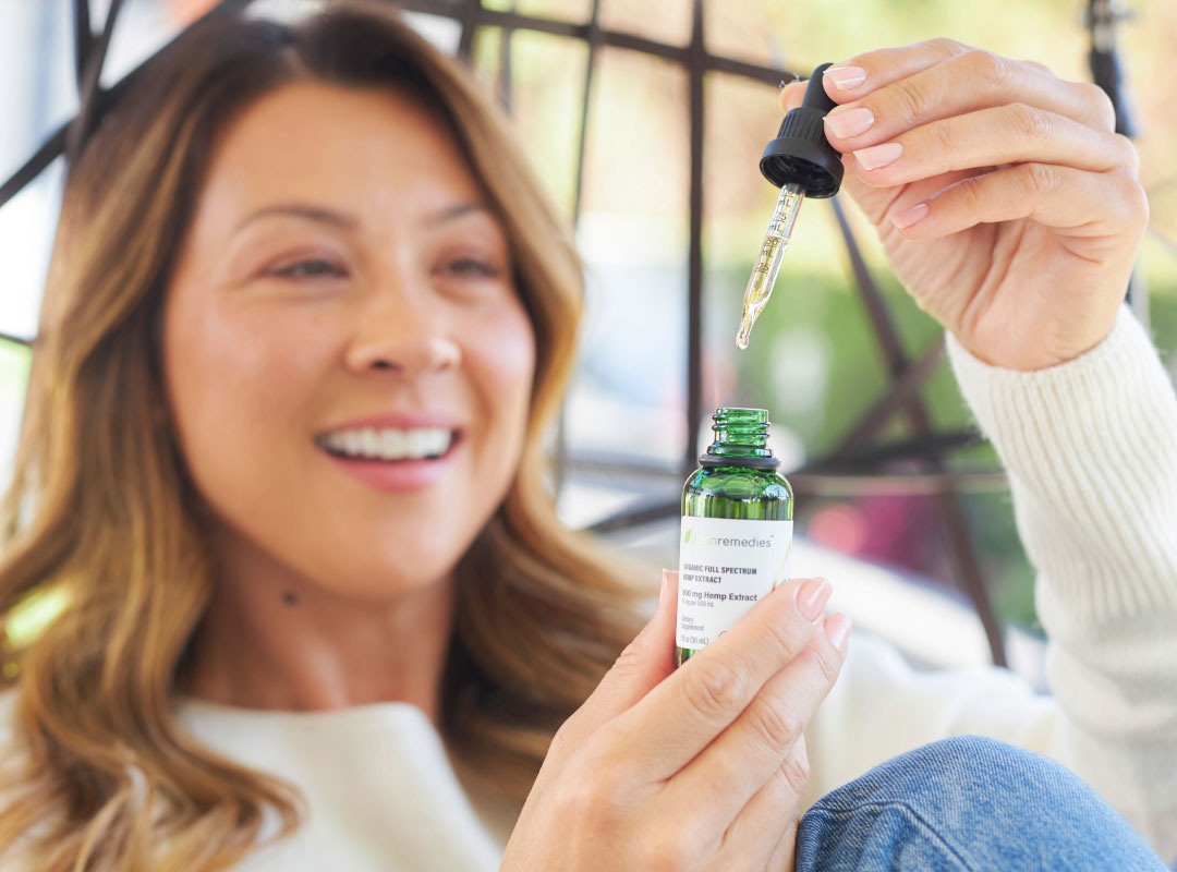 Woman holding Full Spectrum CBD Tincture by Clean Remedies